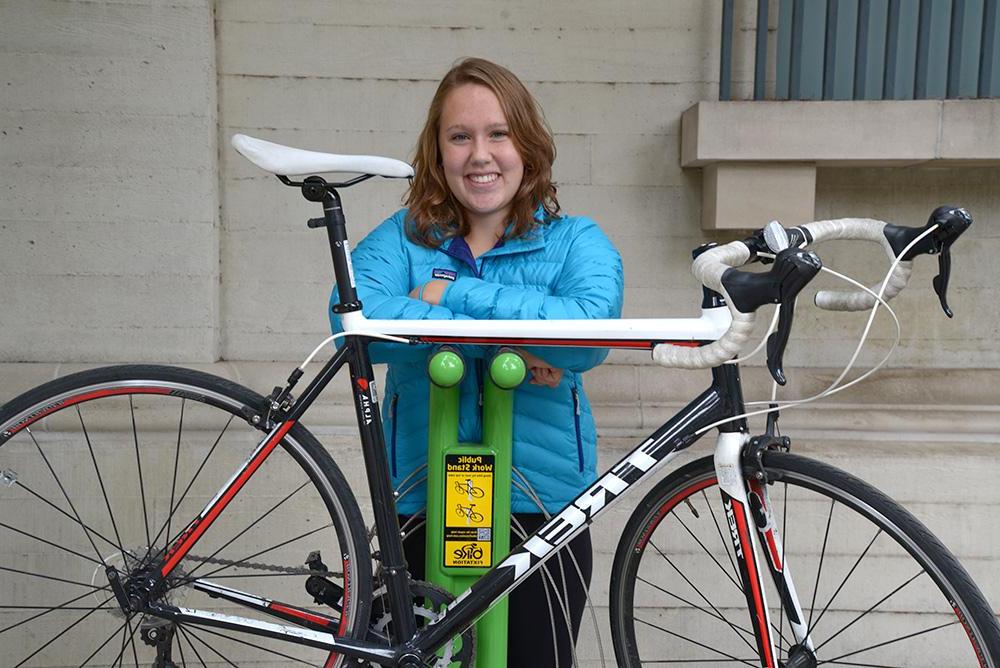 A student with her bike at the bike maintenance station available to students